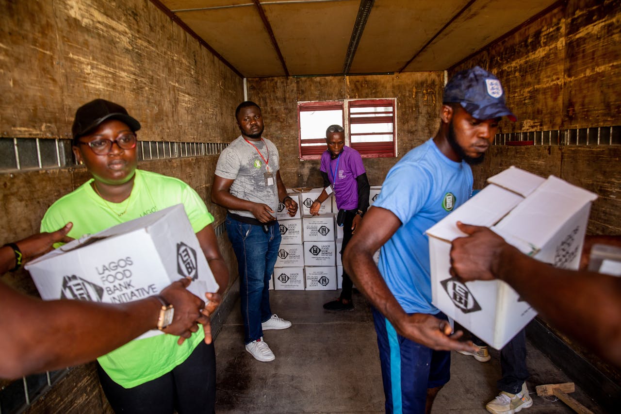 Dedicated volunteers organize food boxes in a truck for community distribution.
